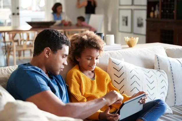 A parent and an elementary school-aged child sitting together on a couch, looking at a book about different types of families, showing open and comforting communication about diversity.