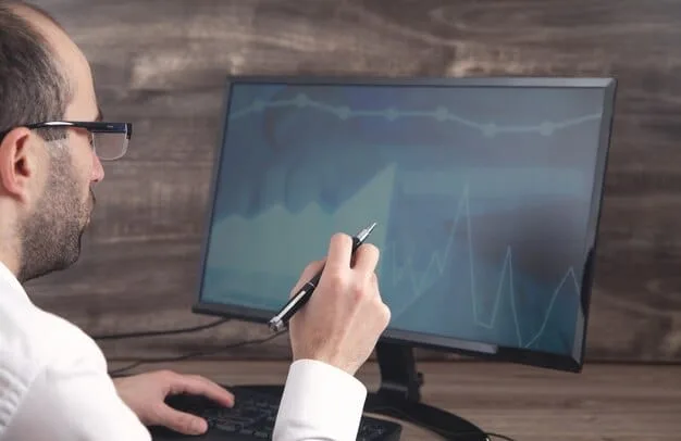 A researcher's hands are shown analyzing data on a computer screen, with graphs and statistical models visible, symbolizing rigorous data collection and analysis in educational research.