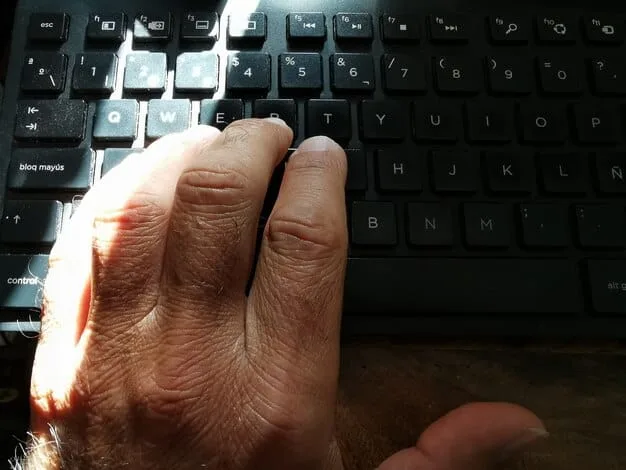 A close-up of a diverse group of hands, including those of an elderly person and a child, reaching for a keyboard and mouse, symbolizing intergenerational digital learning and empowerment.