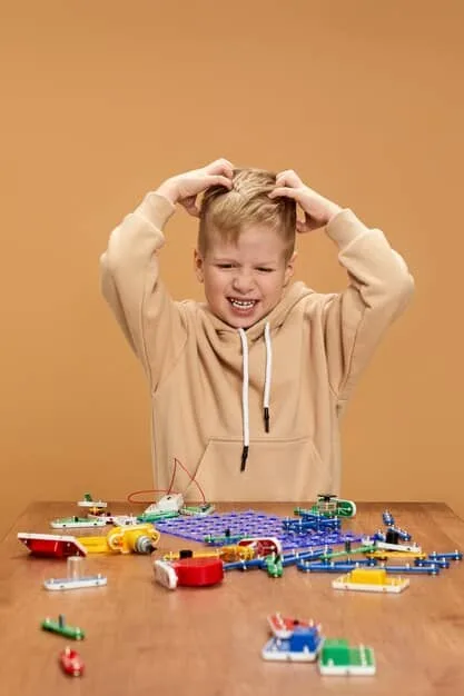 A determined preschooler concentrating intently on fitting together complex interlocking building toys, surrounded by partially constructed creations, illustrating focused problem-solving and perseverance.