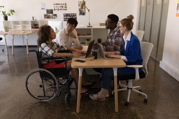 A diverse group of young adults, some with physical disabilities, working collaboratively in a modern office environment, symbolizing the long-term societal impact of inclusive education.