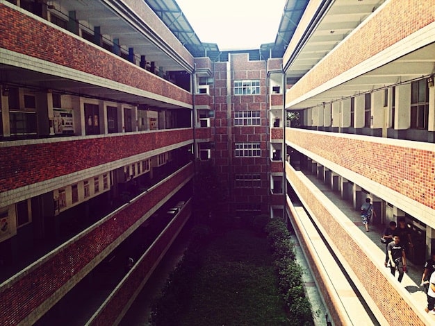 A split image showing one side with overcrowded classrooms and dilapidated school buildings in a low-income neighborhood, and the other side with modern facilities and smaller class sizes in a wealthy district. This represents educational inequality.