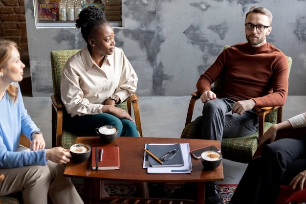 A group of people sitting around a table, engaged in a lively discussion. The atmosphere is collaborative and supportive, with everyone actively listening and contributing their ideas.