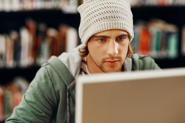 A close-up shot of a Gen Z student in a library, focused on a laptop screen displaying code related to AI algorithms, demonstrating their active engagement in understanding and utilizing AI technology.