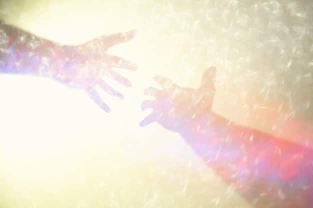 A close-up shot of hands reaching out to each other, symbolizing support and connection. The background is softly blurred with warm colors, representing empathy and understanding.