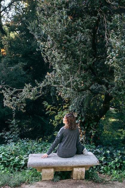 A serene individual practicing mindfulness meditation outdoors in a lush green park. The focus is on the person's peaceful expression and connection with nature, depicting relaxation and stress reduction as potential benefits of therapy.