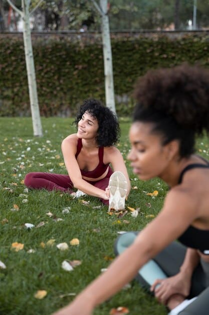 A young diverse Gen Z group participating in an outdoor yoga session at sunset, emphasizing community, mindfulness, and the integration of physical activity into mental well-being practices.