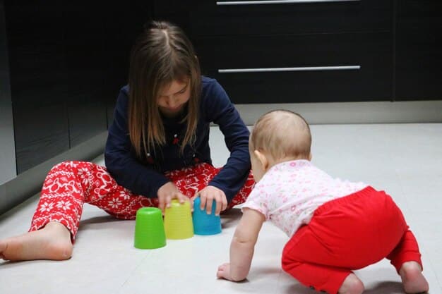 A baby around 6 months old, sitting up and reaching for a toy, showing purposeful interaction and developing motor skills.