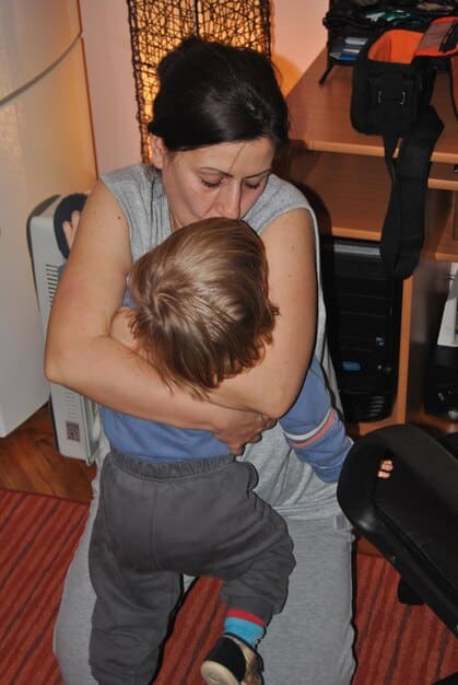 A parent patiently encouraging a child to touch a new texture, demonstrating supportive interaction with a slow-to-warm-up temperament.
