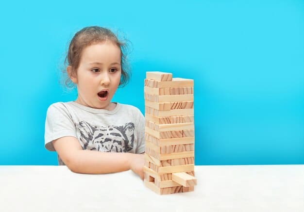 A child carefully building a tall tower with wooden blocks, demonstrating concentration and problem-solving.