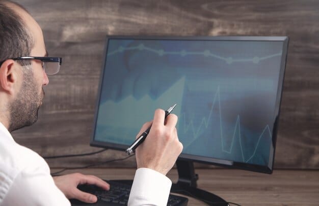 A researcher's hands are shown analyzing data on a computer screen, with graphs and statistical models visible, symbolizing rigorous data collection and analysis in educational research.