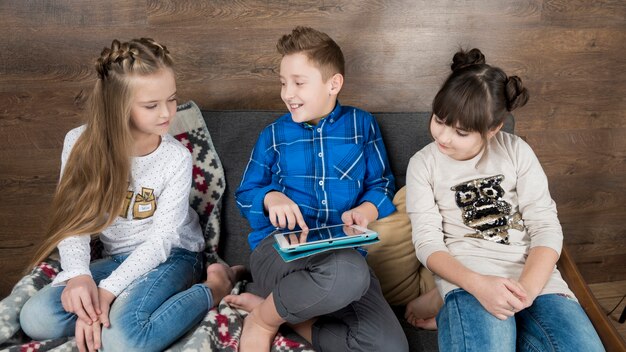 A group of Gen Z children in an ECE setting playing with interactive educational tablets, demonstrating the integration of technology in their learning.
