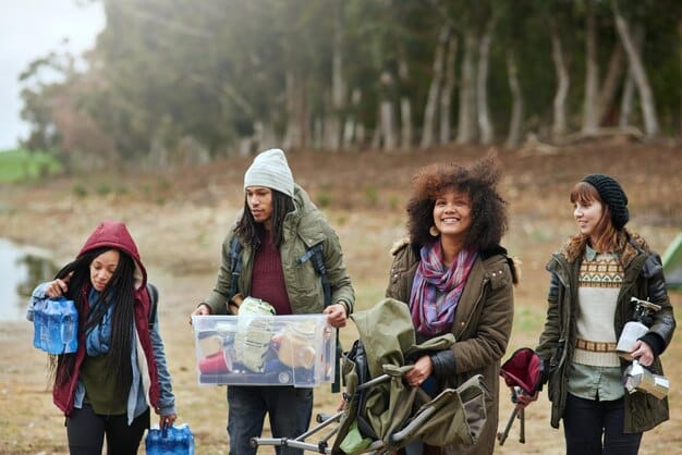 A diverse group of people participating in a local rural community clean-up drive, one person wearing a subtle rainbow-colored hat, indicating community engagement and incremental steps towards inclusivity.