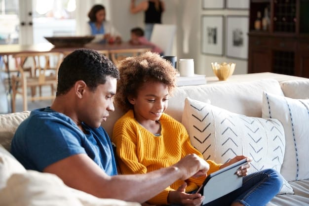 A parent and an elementary school-aged child sitting together on a couch, looking at a book about different types of families, showing open and comforting communication about diversity.