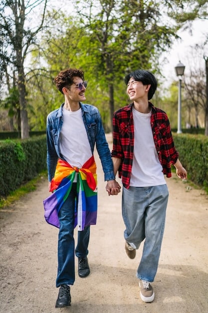A young Gen Z couple, identified as LGBTQ+, holding hands and smiling as they walk through a park, symbolizing hope and partnership amidst a dynamic social backdrop.