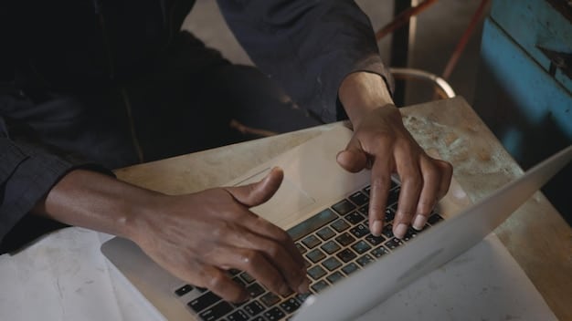 A close-up shot of a young Gen Z individual’s hands typing on a very old, slow, and visibly struggling laptop, demonstrating the challenge of device inequity in an underserved setting.